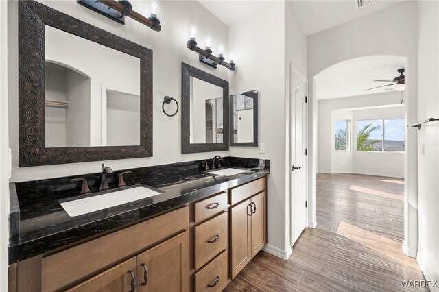 bathroom featuring ceiling fan, a sink, and wood finished floors