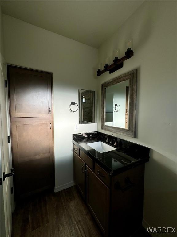 bathroom featuring vanity, baseboards, and wood finished floors