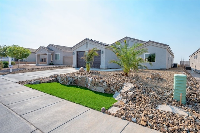 view of front of property with a garage, concrete driveway, a tiled roof, and stucco siding