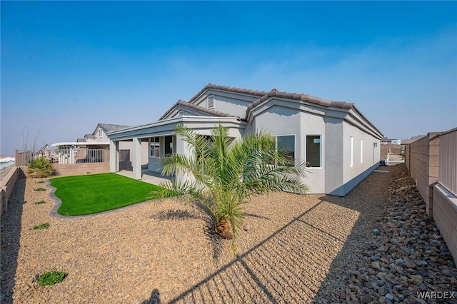 back of house with a patio area, a fenced backyard, a tiled roof, and stucco siding