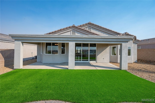 back of property with a yard, fence, a patio, and stucco siding