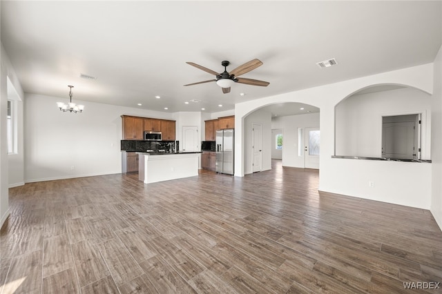 unfurnished living room featuring recessed lighting, visible vents, dark wood finished floors, and ceiling fan with notable chandelier