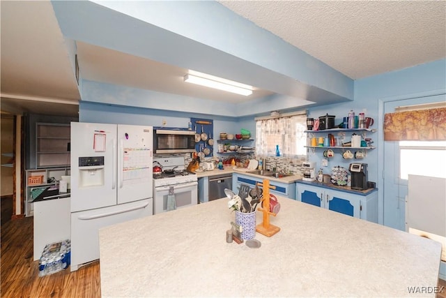 kitchen with plenty of natural light, appliances with stainless steel finishes, light countertops, and a sink