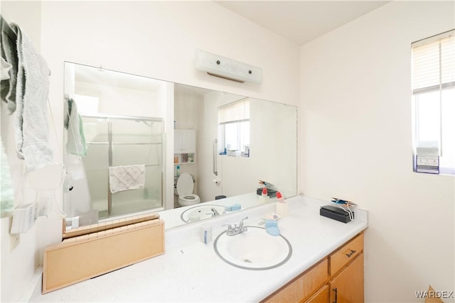 bathroom featuring toilet, a shower with door, an AC wall unit, and vanity