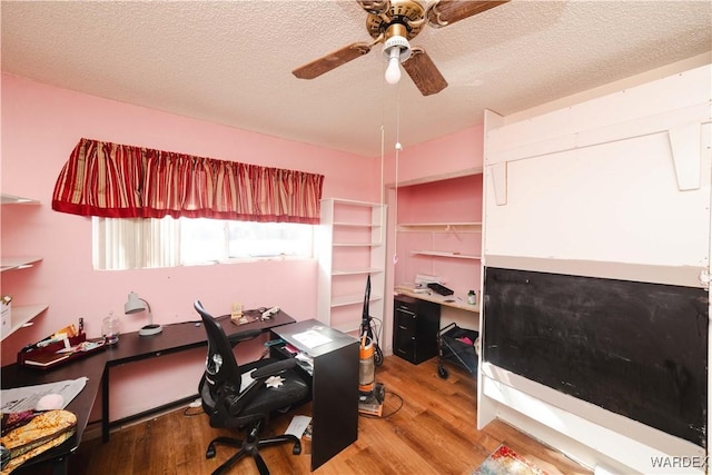 home office featuring ceiling fan, light wood-style flooring, and a textured ceiling