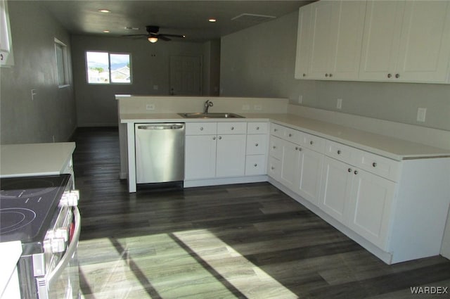 kitchen with light countertops, appliances with stainless steel finishes, a peninsula, and white cabinetry