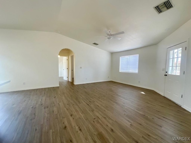 unfurnished living room featuring arched walkways, ceiling fan, dark wood finished floors, and visible vents