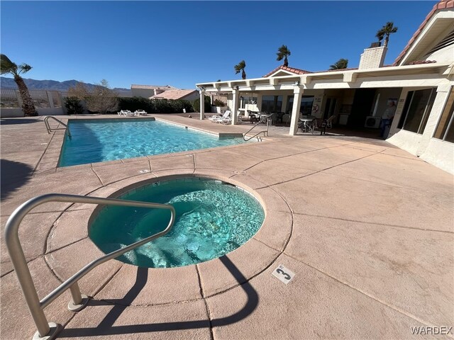 pool with a patio area and a mountain view