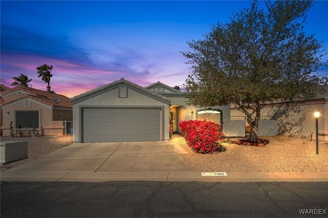 view of front of home featuring a garage, concrete driveway, and stucco siding