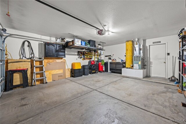 garage featuring heating unit, a workshop area, and a garage door opener