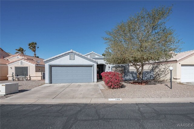 view of front of property with a garage, a tiled roof, concrete driveway, and stucco siding