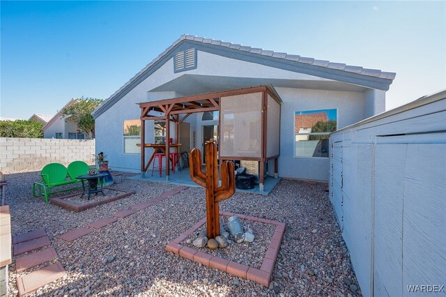 exterior space with stucco siding, fence, and a patio