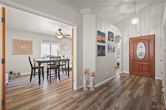 entryway featuring dark wood-style floors, baseboards, and arched walkways