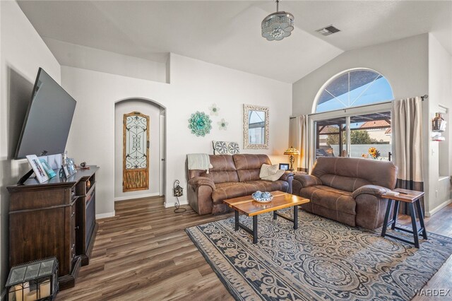 living room with lofted ceiling, dark wood-style flooring, visible vents, and baseboards