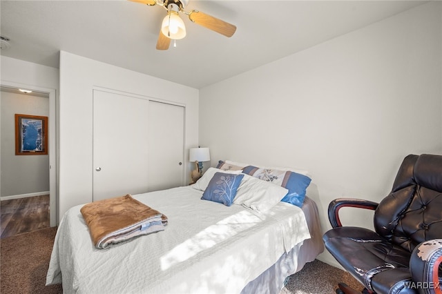 bedroom featuring ceiling fan, a closet, dark wood-style floors, and baseboards