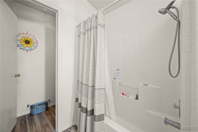 bathroom featuring shower / bath combo, baseboards, and wood finished floors