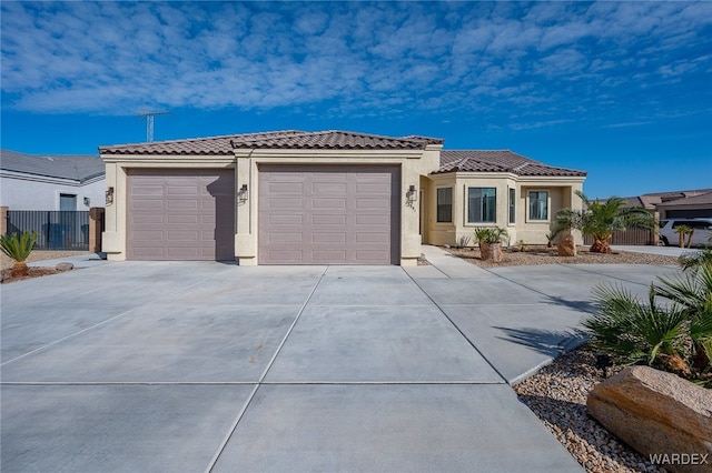 mediterranean / spanish home featuring a tiled roof, an attached garage, driveway, and stucco siding