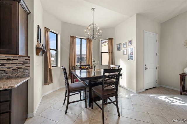 dining room with an inviting chandelier, baseboards, and light tile patterned flooring