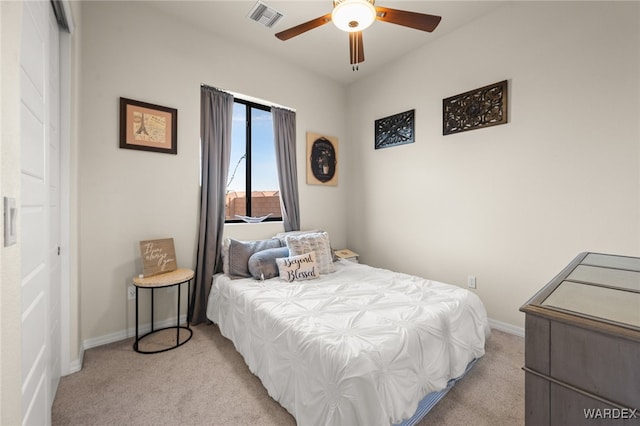 bedroom with baseboards, visible vents, a ceiling fan, light colored carpet, and a closet