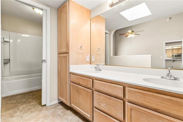 1951 E Oatman Pl, Mohave Valley, AZ 86440 - full bath featuring double vanity, a skylight, ceiling fan, shower / washtub combination, and tile patterned floors