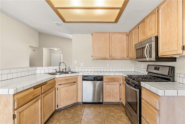 1951 E Oatman Pl, Mohave Valley, AZ 86440 - kitchen featuring appliances with stainless steel finishes, light brown cabinetry, a peninsula, lofted ceiling, and light tile patterned flooring