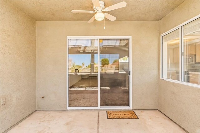 1951 E Oatman Pl, Mohave Valley, AZ 86440 - view of exterior entry with a ceiling fan, stucco siding, and a patio