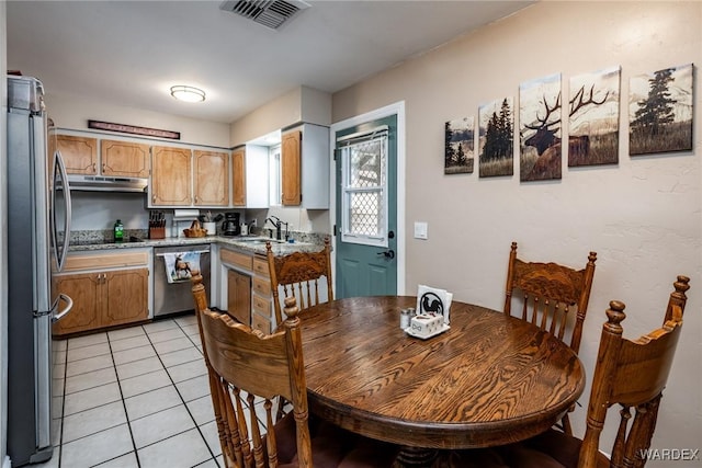 dining area with light tile patterned floors and visible vents