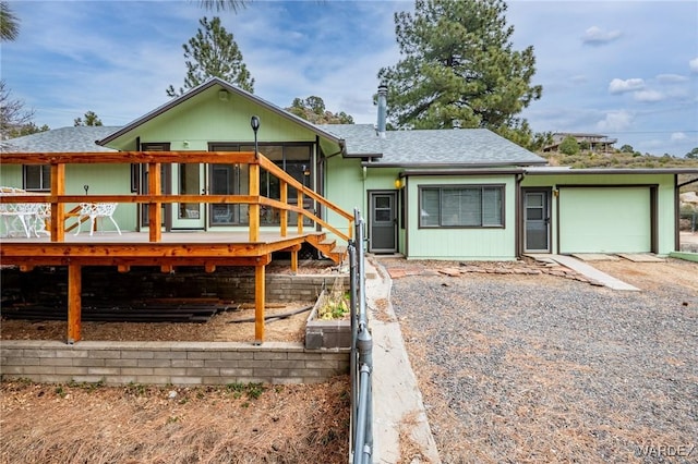 view of front of home with an attached garage, driveway, and a shingled roof