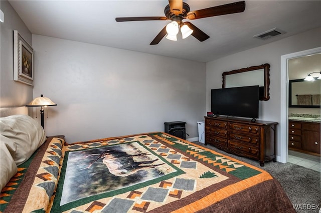 bedroom with visible vents, ensuite bathroom, carpet, baseboards, and ceiling fan