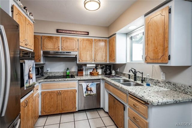 kitchen with light stone countertops, under cabinet range hood, light tile patterned flooring, stainless steel appliances, and a sink