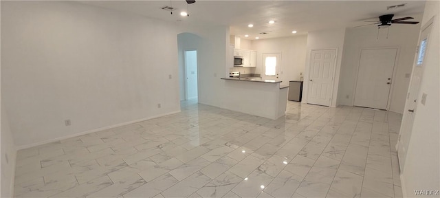 interior space featuring a ceiling fan, marble finish floor, and white cabinetry