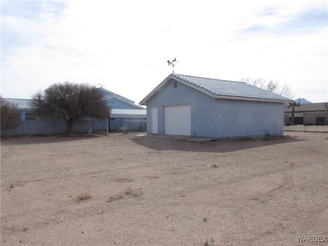 detached garage featuring fence