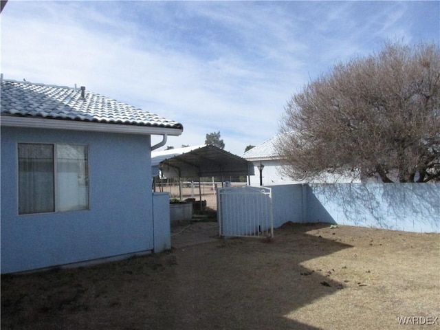 view of yard with a detached carport and fence