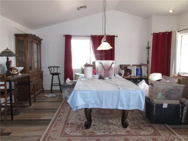 bedroom featuring lofted ceiling, multiple windows, visible vents, and wood finished floors