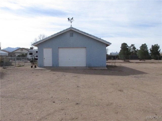 detached garage featuring fence