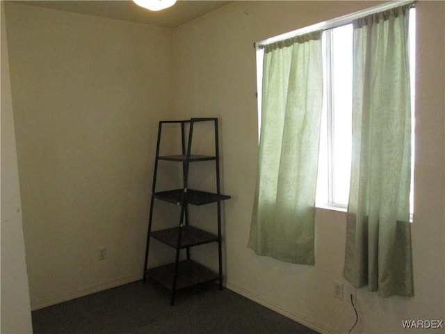 unfurnished room with baseboards