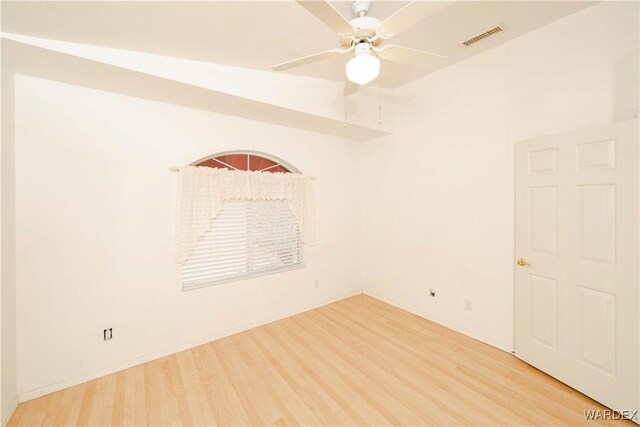 spare room featuring baseboards, light wood-style flooring, visible vents, and a ceiling fan