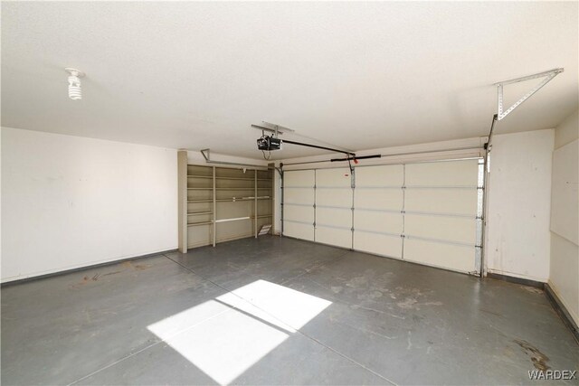 garage featuring a garage door opener and baseboards