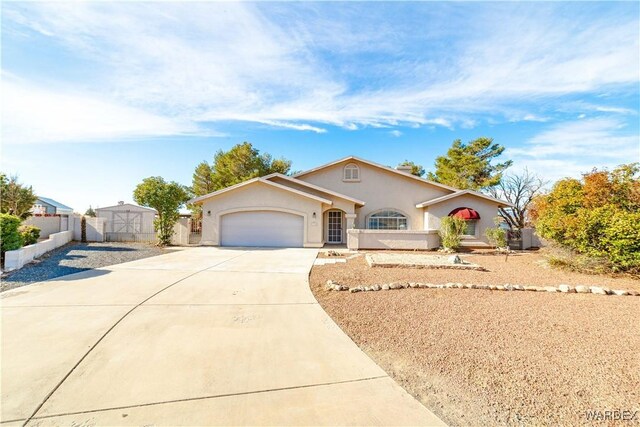 view of front of home featuring a garage, fence, concrete driveway, and stucco siding