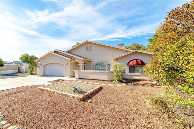 view of front of home with driveway, a garage, fence, and stucco siding