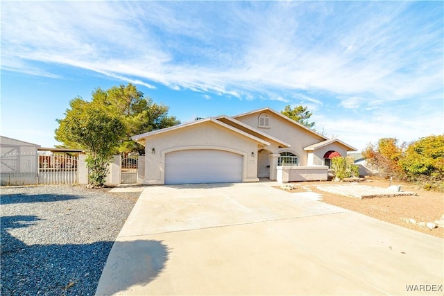 view of front facade featuring a garage, fence, concrete driveway, a gate, and stucco siding