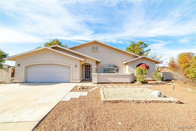 view of front facade featuring a garage, driveway, and stucco siding