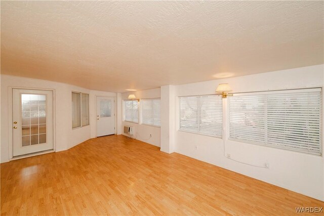 spare room with a textured ceiling and wood finished floors