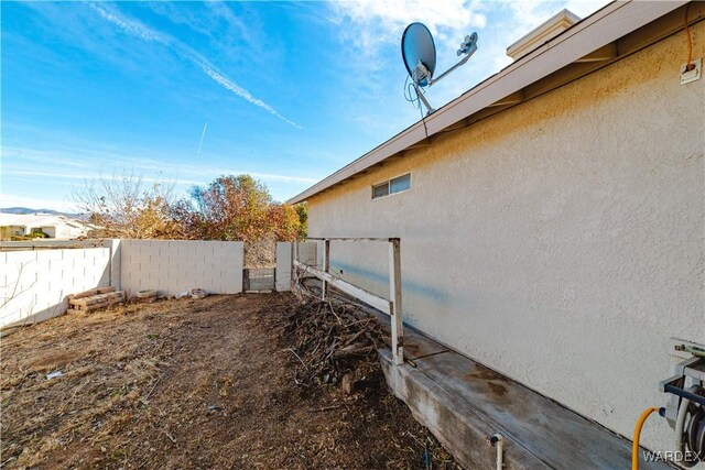 view of property exterior with fence and stucco siding