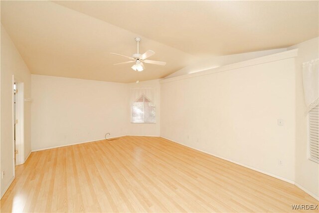 empty room featuring light wood-style floors, vaulted ceiling, and ceiling fan