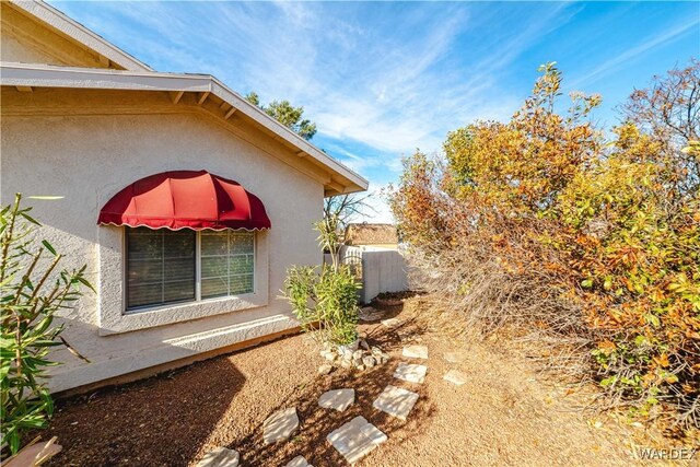 view of home's exterior with fence and stucco siding