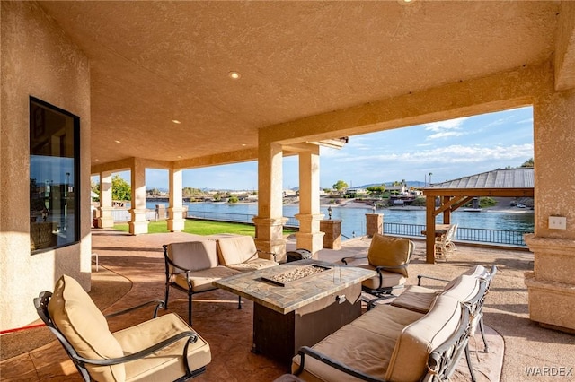 view of patio / terrace with a water view, a fire pit, and a gazebo