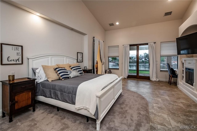 bedroom featuring high vaulted ceiling, access to outside, and visible vents