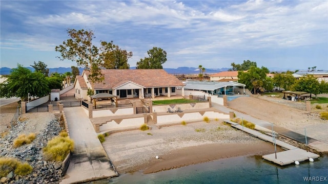 back of property with fence and a water and mountain view