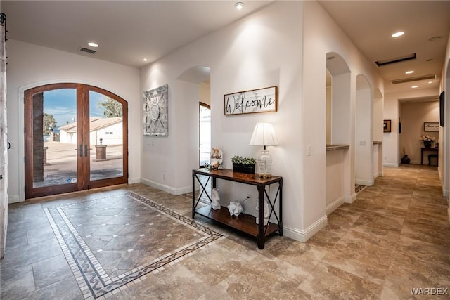 interior space with visible vents, arched walkways, baseboards, and recessed lighting